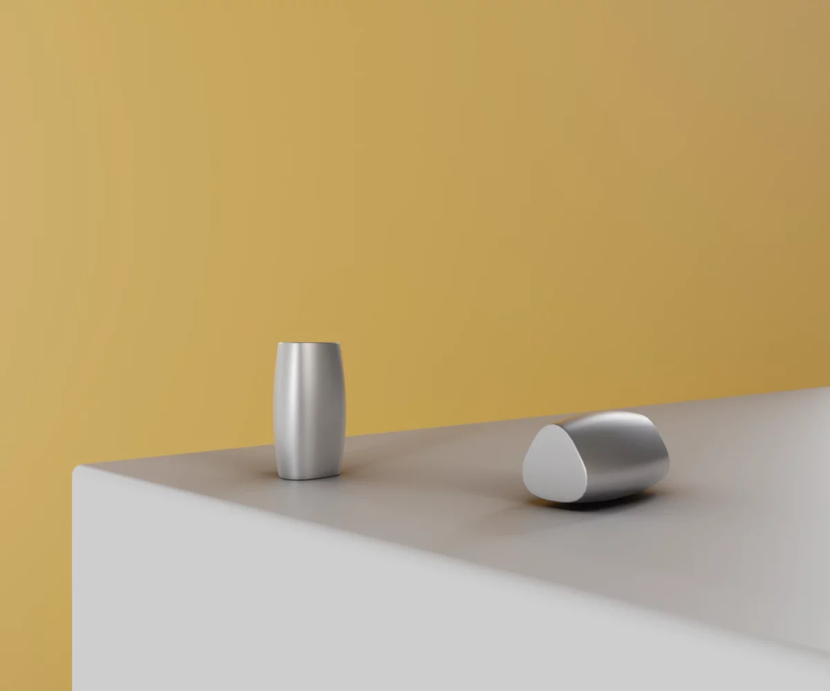 Zwei silberne Zink-Knäufe vom Typ KB-ZI-10060 auf einer weißen Fläche vor gelbem Hintergrund.