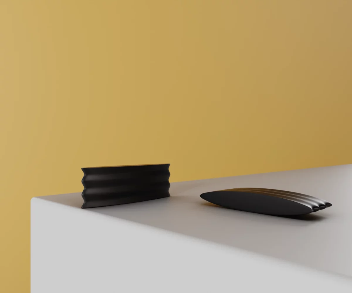 Zwei mattschwarze Zink-Knäufe vom Typ KB-ZI-11001 auf einer weißen Fläche vor gelbem Hintergrund.