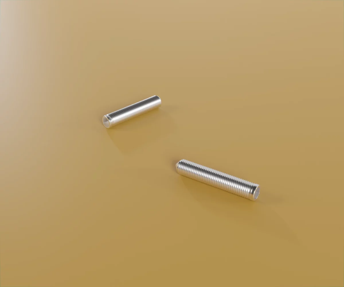 Zwei edge-plus-Zubehörteile vom Typ FC-ST-30003 auf einem gelben Hintergrund. Hierbei handelt es sich um Inbusschrauben für das edge-plus-System.